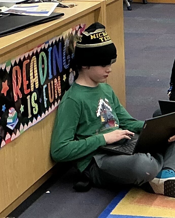 Student using his chromebook in the media center