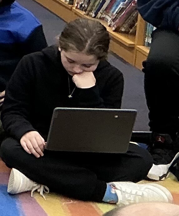 Student using her chromebook in the media center